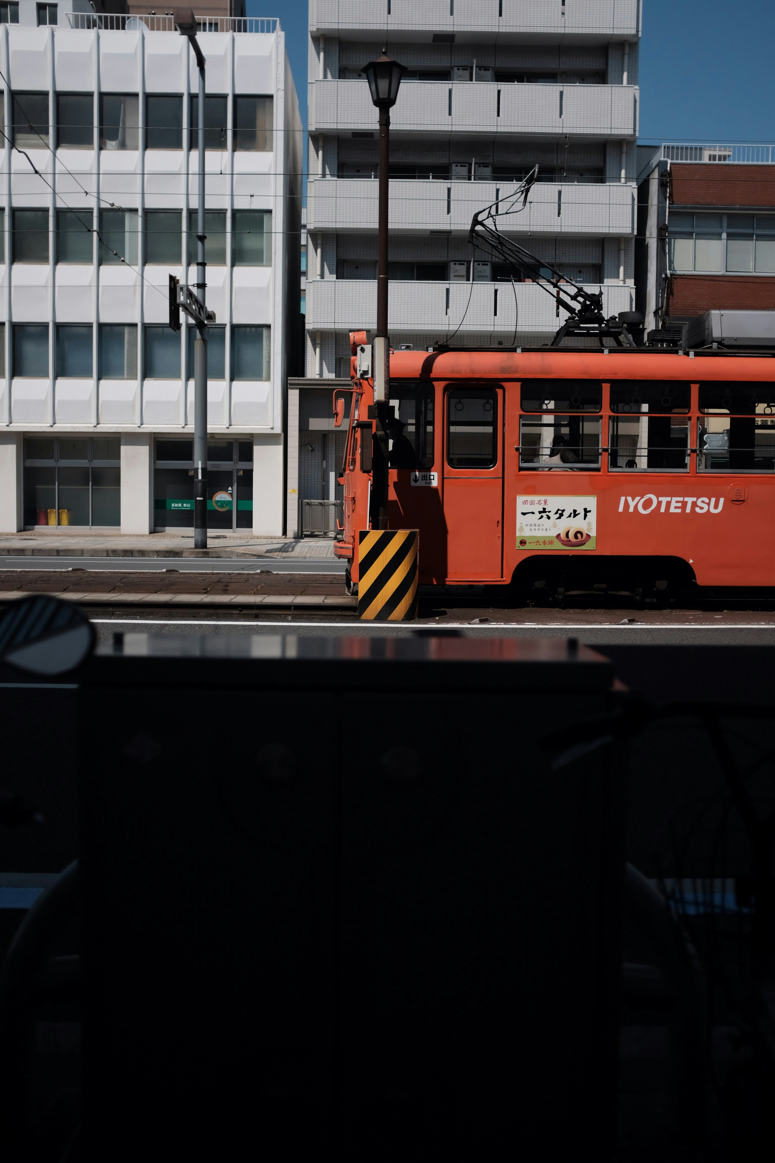 red and black train on rail road near building during daytime